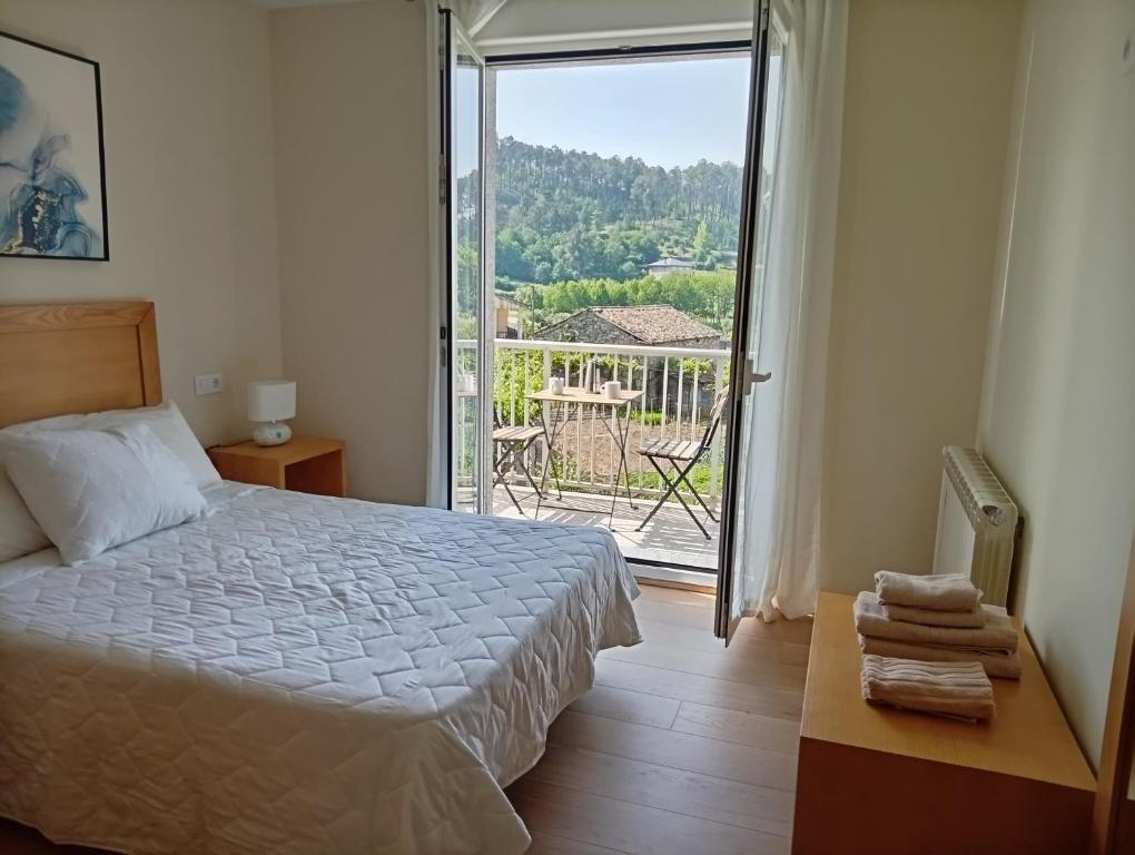 a bedroom with a bed and a large sliding glass door at Casa Da Ponte in Lobios