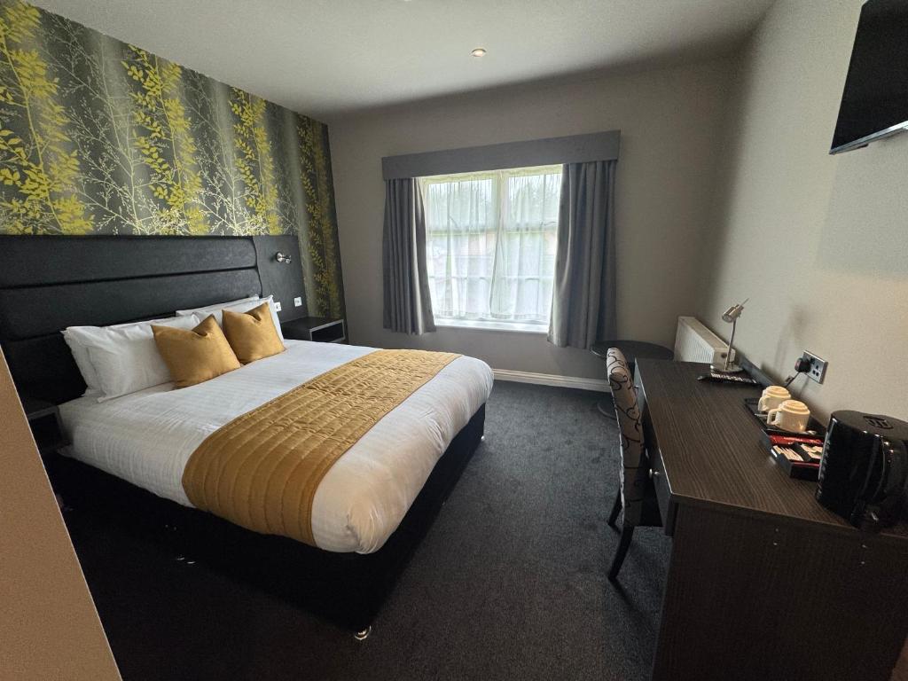 a hotel room with a large bed and a desk at Northallerton Motel in Northallerton