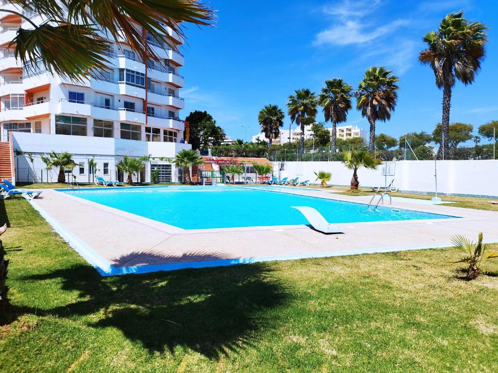 an empty swimming pool in front of a building at Rochavaumar in Portimão