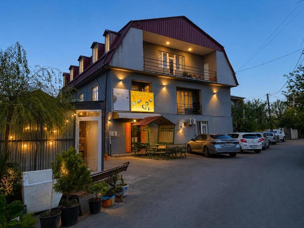a large house with cars parked in front of it at Palma Hostel in Batumi