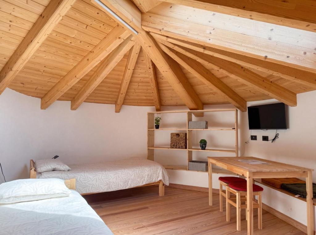 a bedroom with two beds and a table and a desk at Freeabile 51 - Cevedale - stanza in centro in Sondrio