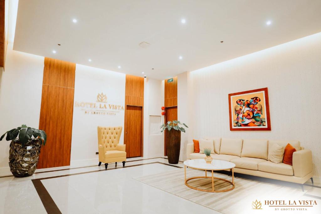 a living room with a couch and a table at Hotel La Vista by Grotto Vista in Mangangpico