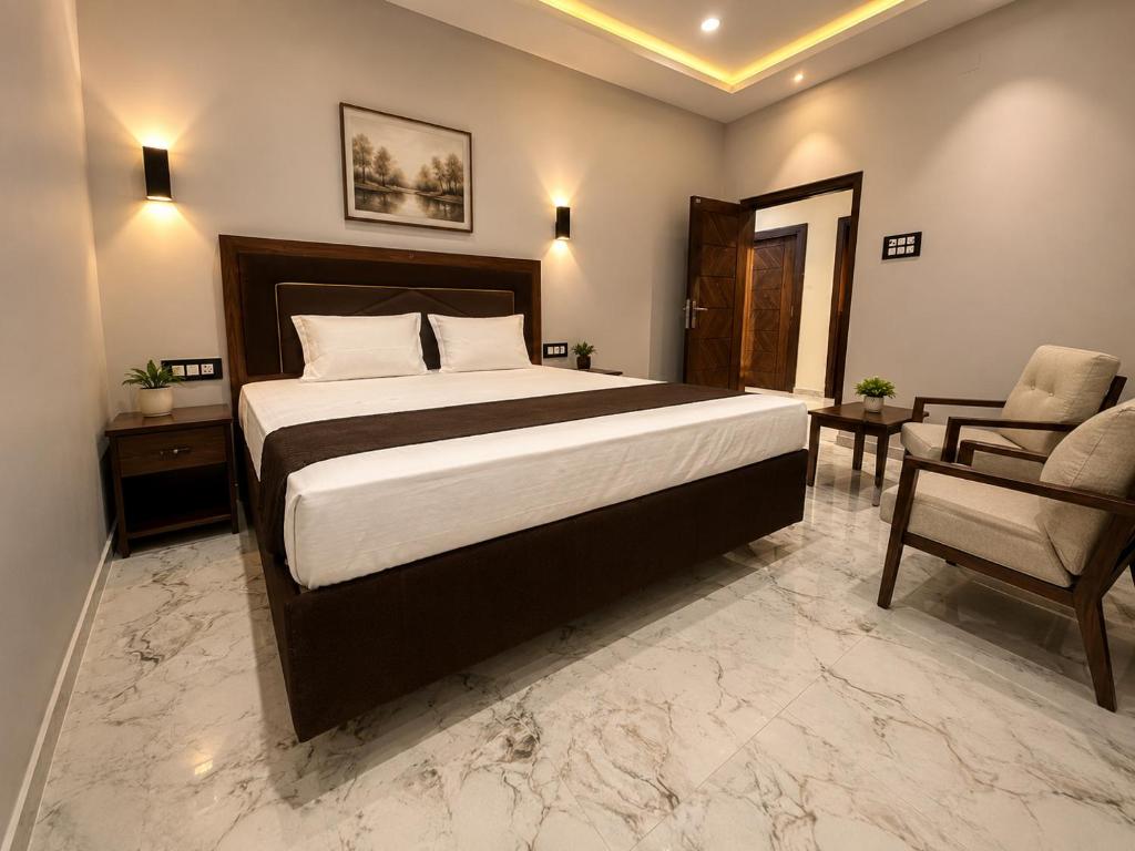 a bedroom with a large bed and a chair at Hotel Bhagirath Palace in Ahraurā Road
