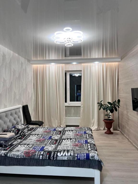 a bedroom with a bed and a chandelier at Дім Гаваї in Chechelivka