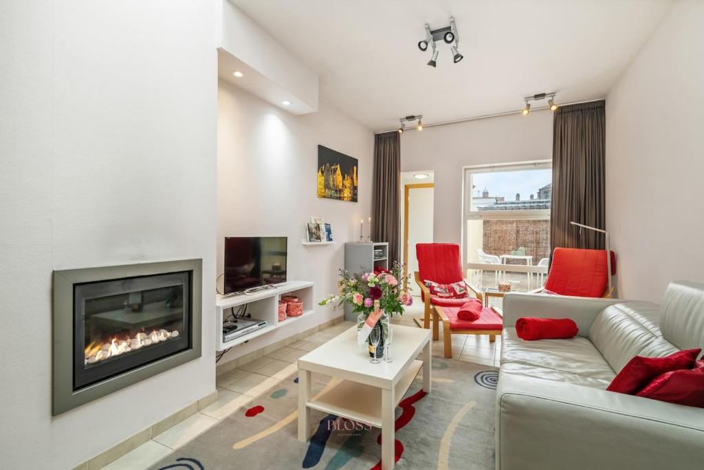 a living room with a couch and a fireplace at Parkhuisje by BLOSS in Bruges