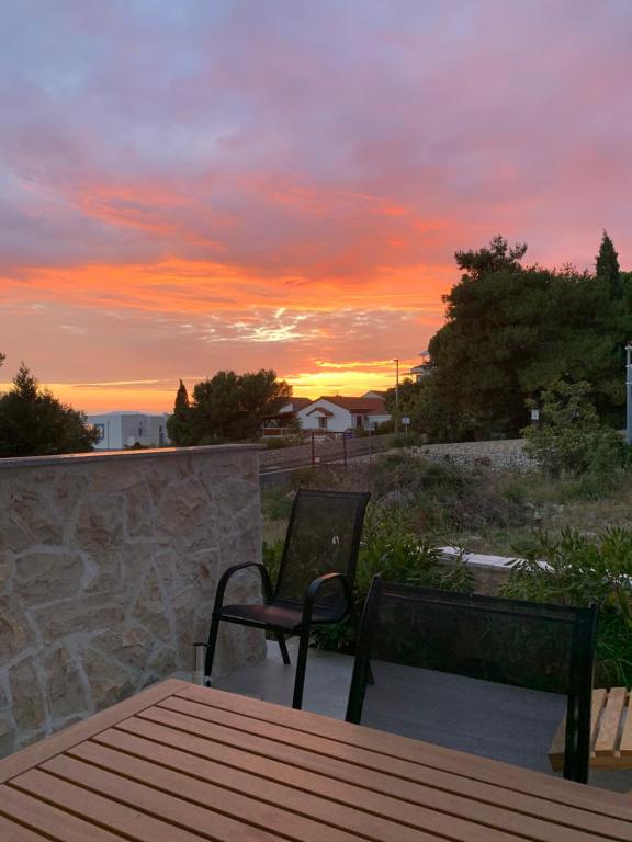 a table and chairs on a patio with a sunset at Villa Legacy with privat heating pool in Novalja