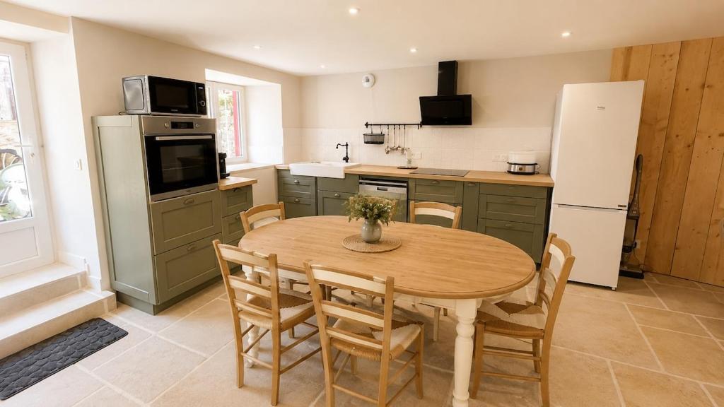 a kitchen with a wooden table and a refrigerator at Maison 8 personnes avec terrasse in Verdun