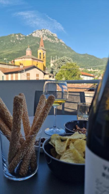 a table with a glass of wine and some food at Lake Como Terrace Suite in Mandello del Lario