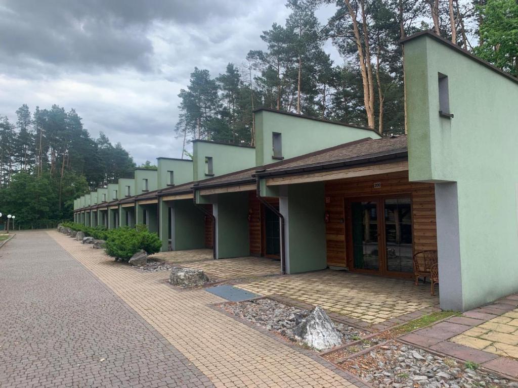 a row of buildings with trees in the background at Pod Grzybkiem in Zawady