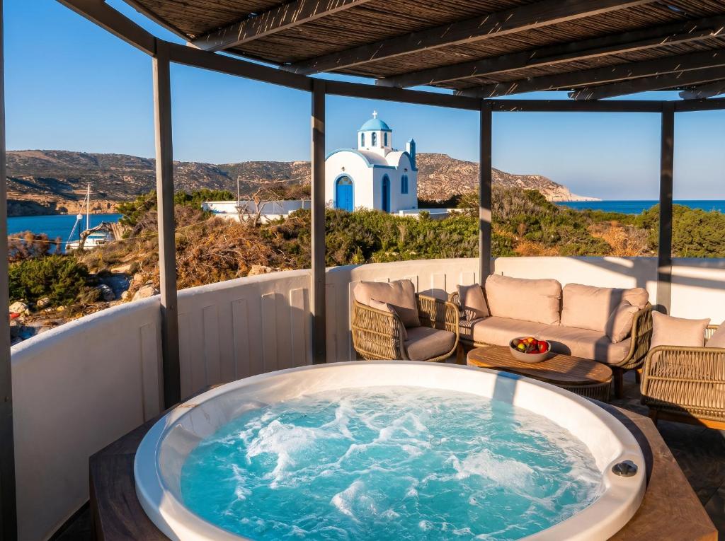 a jacuzzi tub on the balcony of a house at Vista Maris Suites in Amoopi