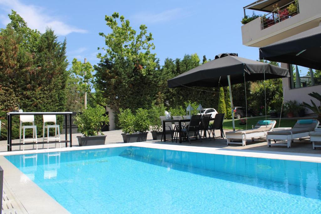 a swimming pool with a table and chairs and an umbrella at Villa Constangie in Marathon