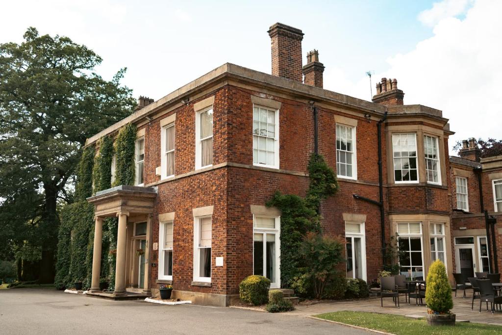 a large brick building with white windows on a street at Farington Lodge Hotel in Preston