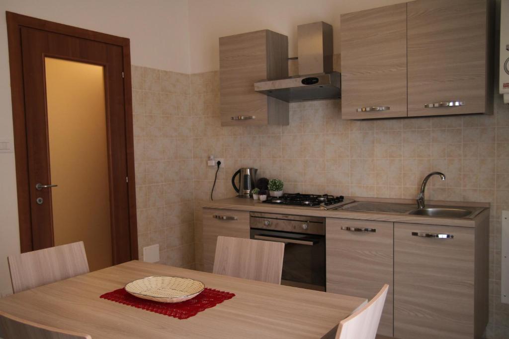 a kitchen with a table and a stove and cabinets at Aduepassidallafiera in Bologna