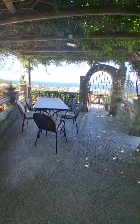 a patio with a table and chairs and a gate at Casa Enza in Forio d'Ischia