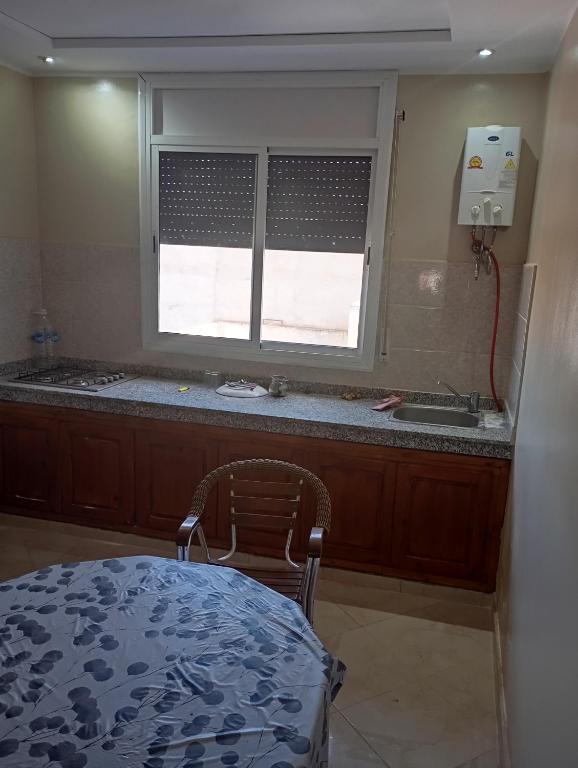 a kitchen with a table and a sink and a window at Saïda Friends in Zemmour Touirza