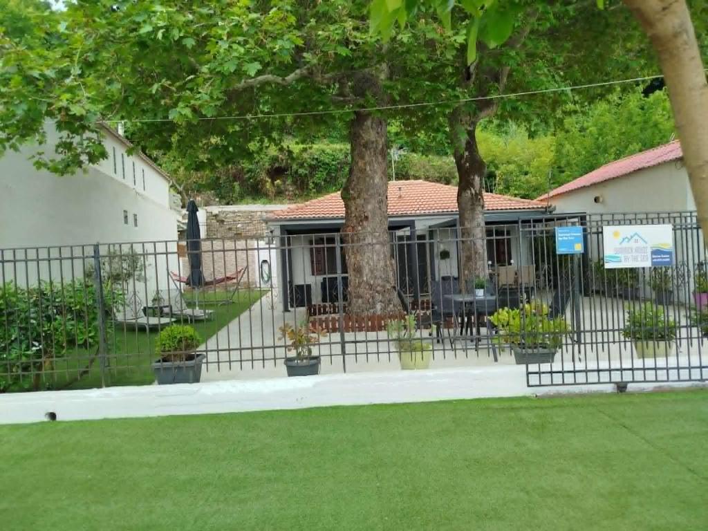 a fence in front of a building with trees at Summer House by the Sea in Chorefto