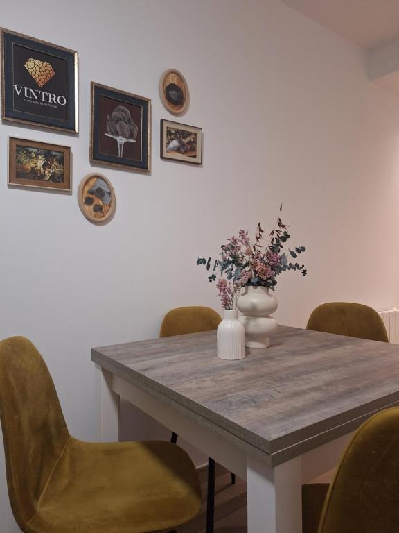 a dining room table with chairs and a vase with flowers at Aromas del Jiloca, la Trufa Negra in Calamocha