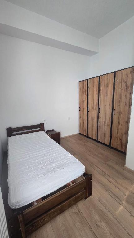 an empty room with a bed and wooden cabinets at Ubytovna Chropyně in Kroměříž
