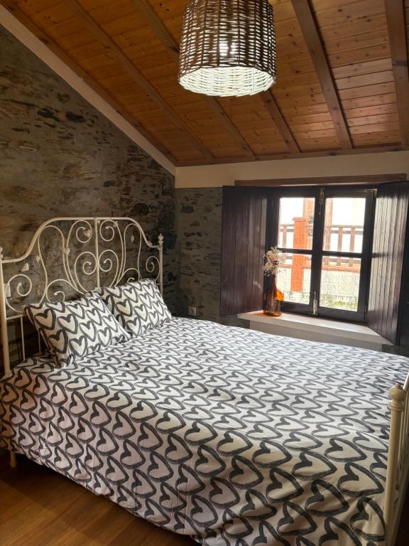 a bedroom with a large bed and a chandelier at Casa gallega Cedeira in Montojo