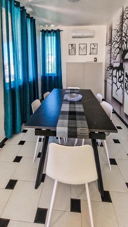 a dining room with a black table and chairs at Dream Houses in Marina di Palma