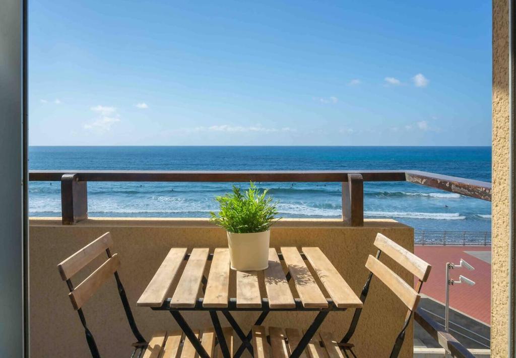 a wooden table with a potted plant on a balcony at Numancia 1-1A in Las Palmas de Gran Canaria