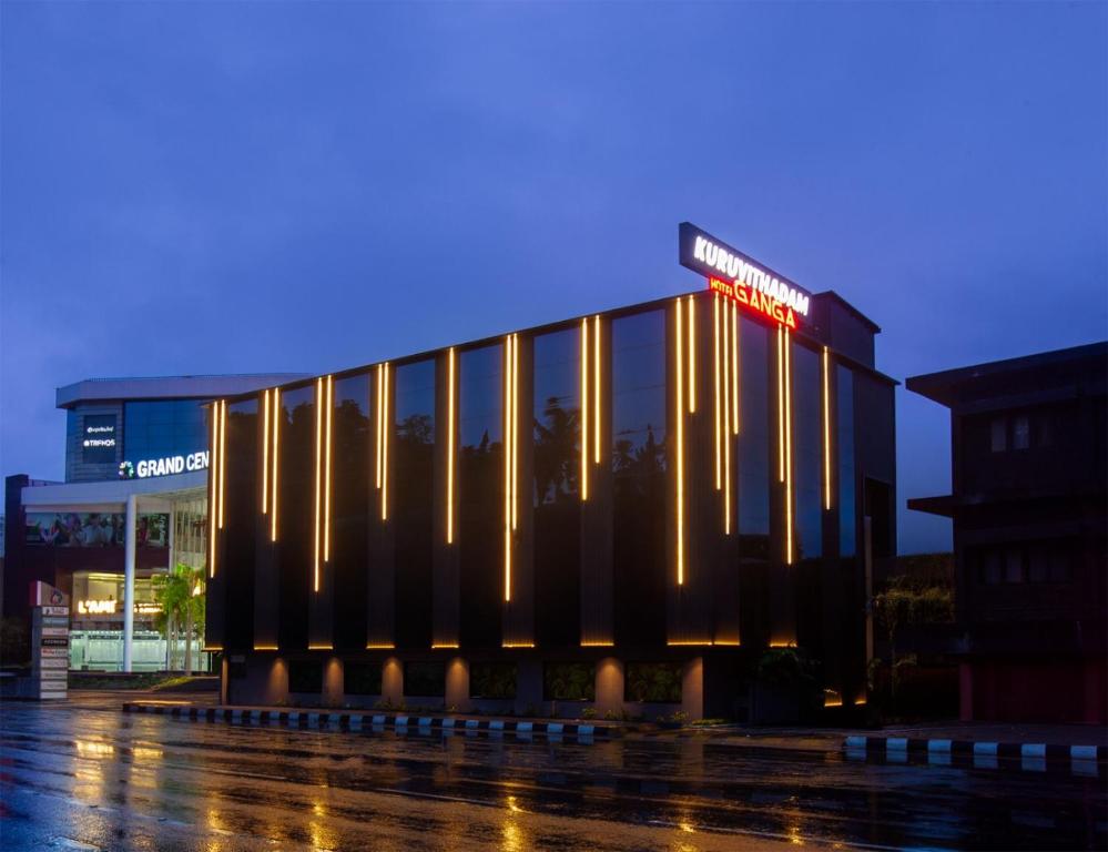 a building with a sign on it at night at HOTEL GANGa in Mūvattupula