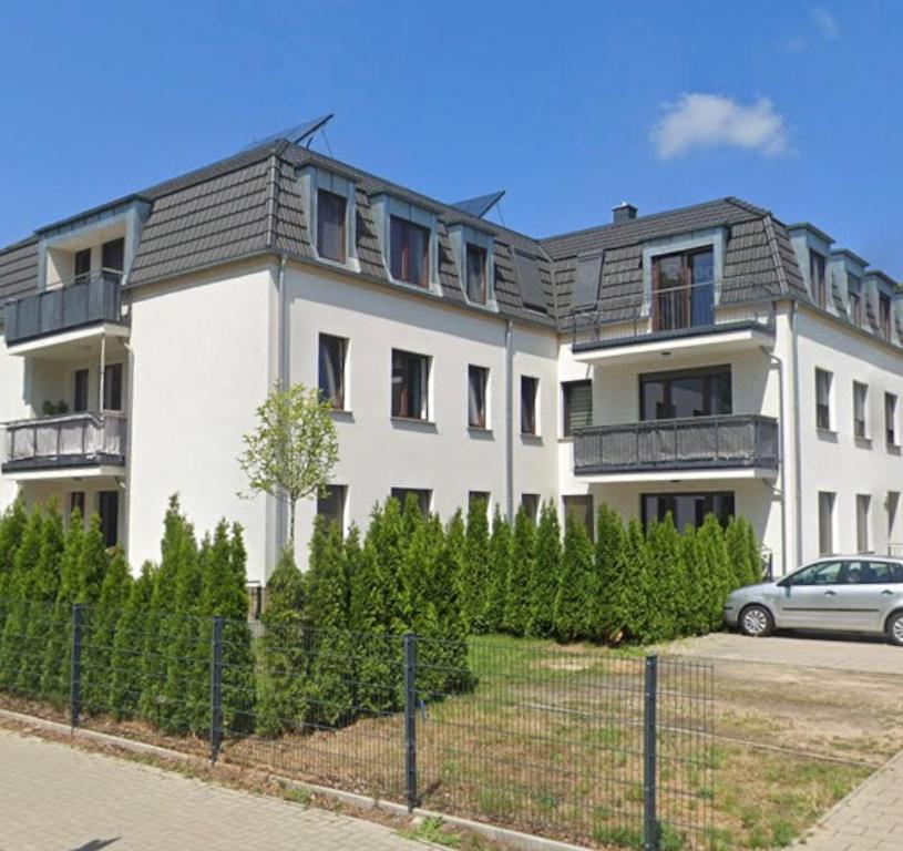 a white building with a car parked in front of it at OMNI - Homes - Waldstraße in Falkensee