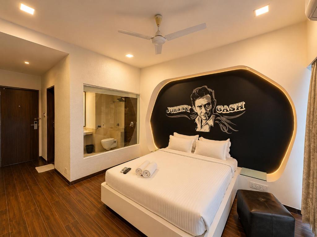 a bedroom with a large bed with a poster on the wall at Cosset - A Boutique Hotel in Lonavala