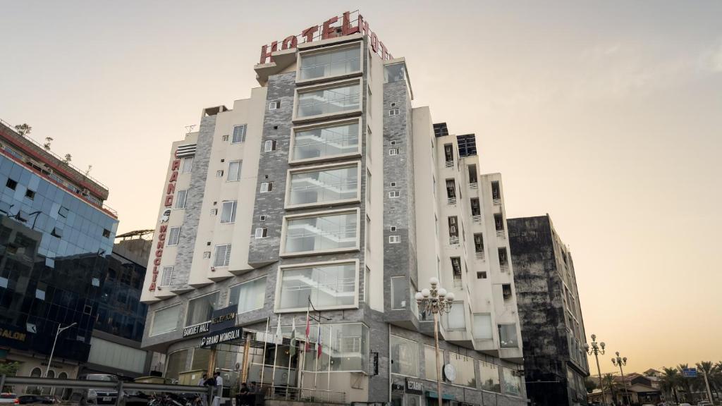 a tall white building with a sign on it at Grand Mongolia in Rawalpindi