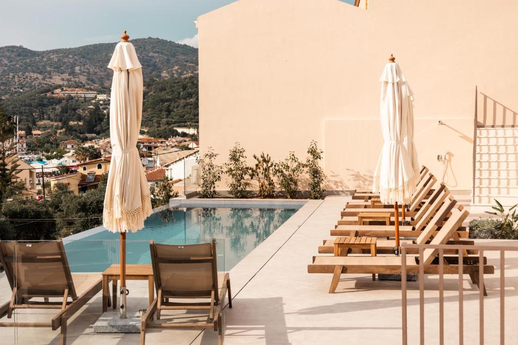 eine Hoteldachterrasse mit Stühlen und Sonnenschirmen in der Unterkunft Sunstar Suites in Syvota