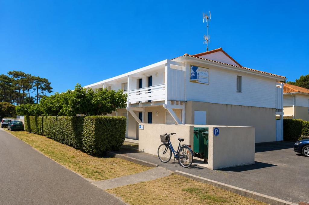 a bike parked in front of a white house at Résidence Au Pitot, Biscarrosse-Plage in Biscarrosse-Plage