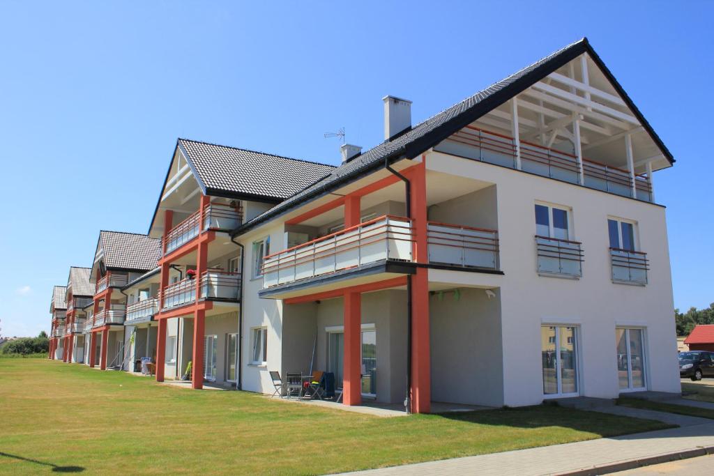 a row of apartment buildings with red and white at Piękny Apartament - Darłówko Wschodnie in Darłówko