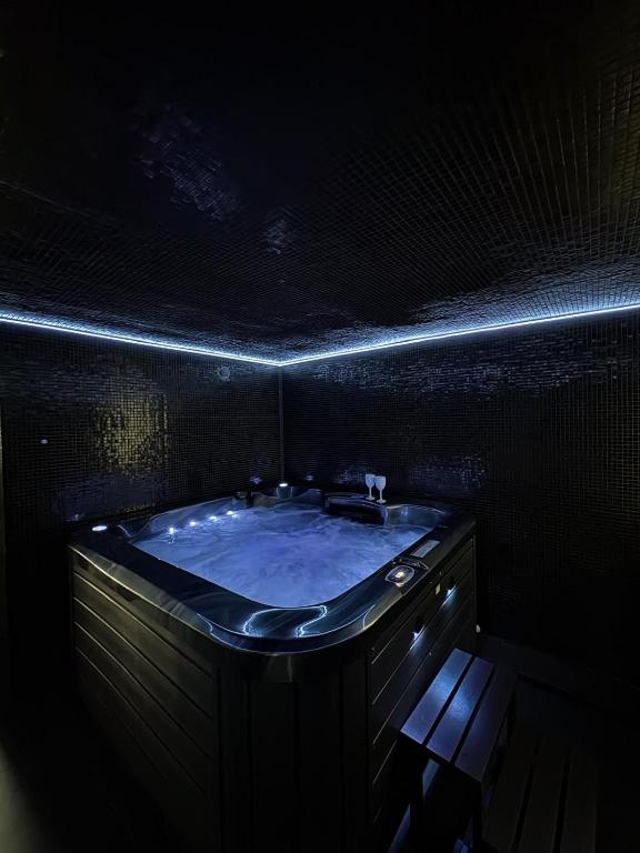 a dark bathroom with a tub with lights on it at Moonlight jacuzzi in Stargard