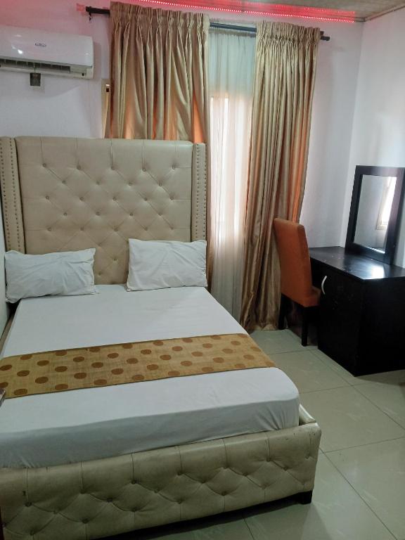 a bedroom with a large bed with a desk and a bed sidx sidx at Light house hotel lekki phase 1 in Araromi