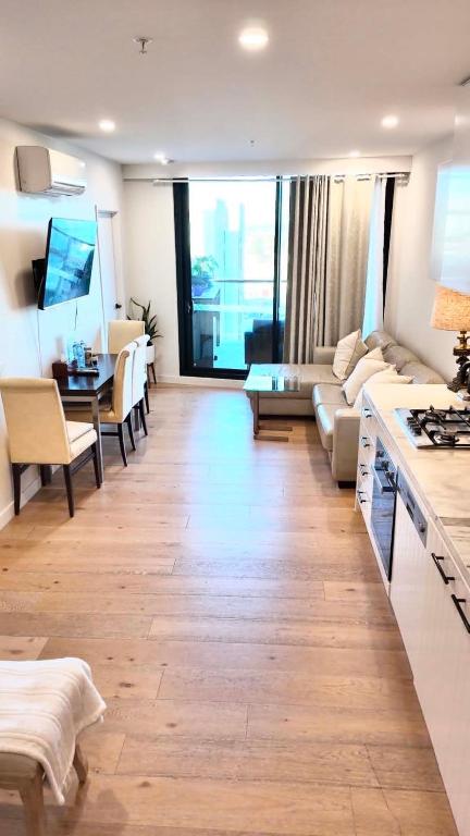 a living room with a couch and a table at Premium Twin King Ensuites apartment with Double Sofa Bed at M-city Apartment Complex - Infinite Mountain View - Monash Uni & Hospital Clayton, 3168, Victoria, Australia - Free parking, Wifi, Amenities, Tea and Coffee in Clayton North