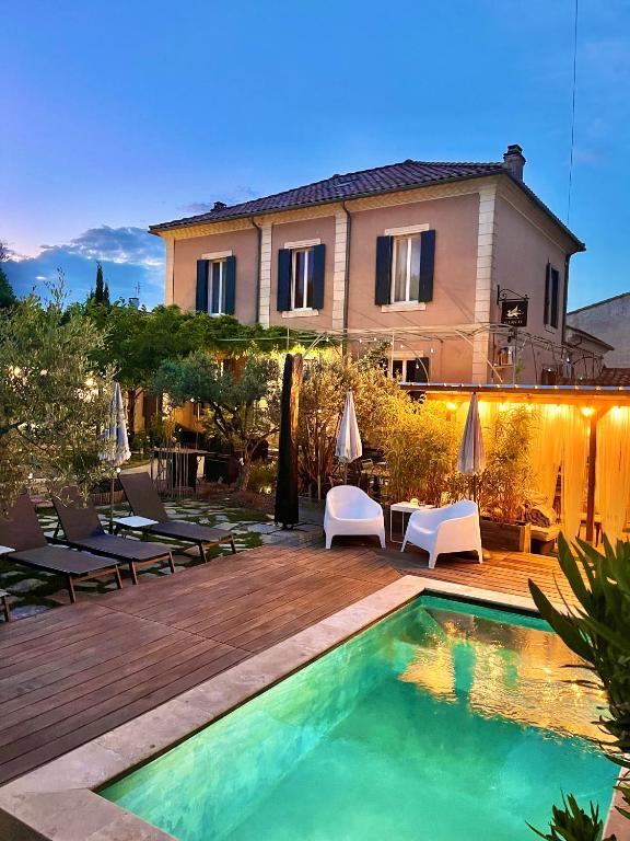 a villa with a swimming pool in front of a house at La maison Gerval in Bédoin