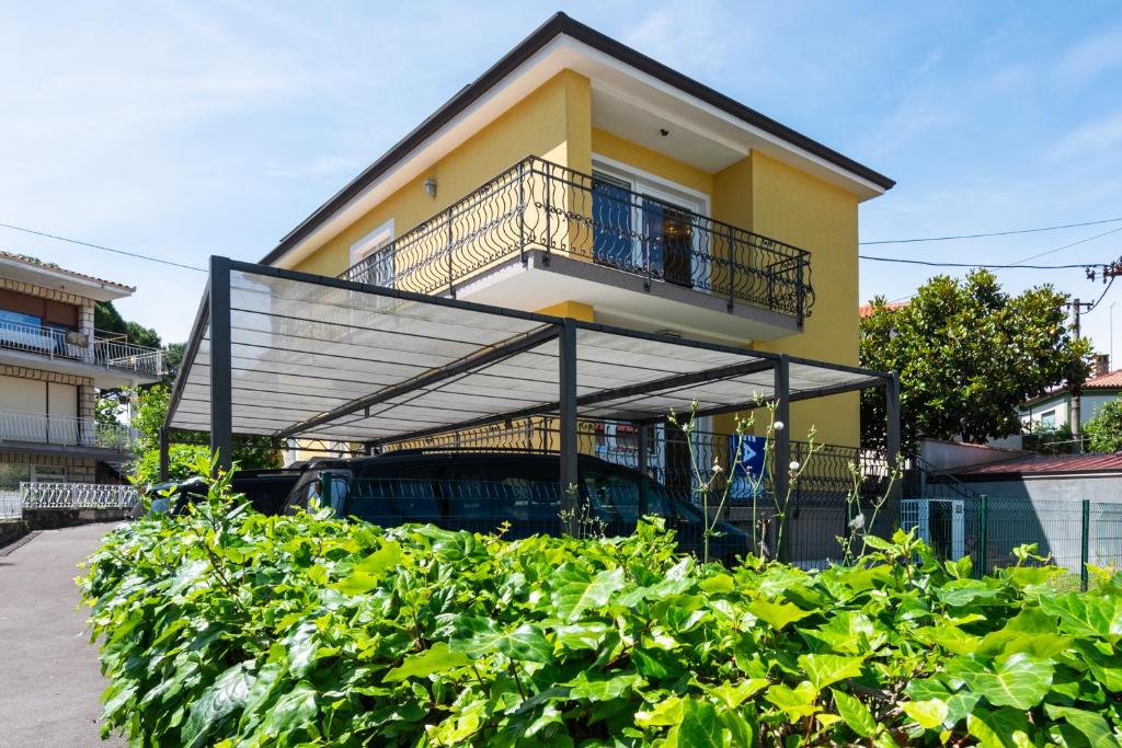 a yellow house with a balcony on a street at Residence Almarea by Locap Group in Izola