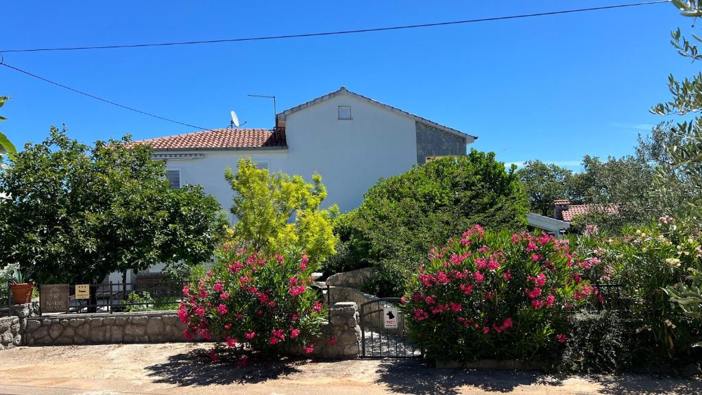 a white house with flowers in front of it at Villa Rossi in Krk
