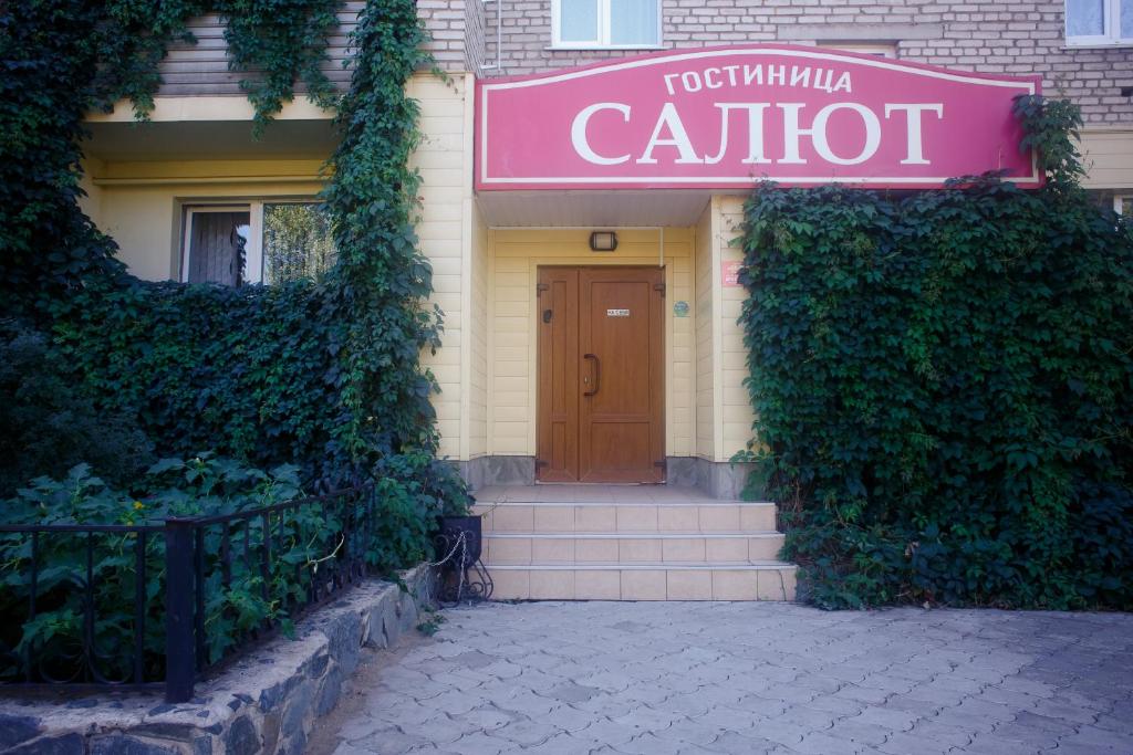 a red door leading to a building with a blue door at Hotel Salut in Orsk