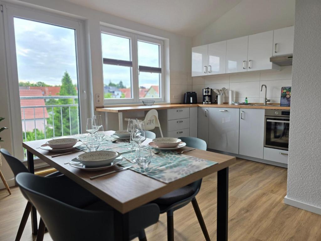a kitchen with a wooden table with glasses on it at Ferienwohnung Rückerts Gartenblick in Nordhausen
