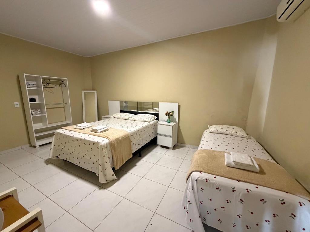 a bedroom with two beds and a mirror at Casa mobiliada AR01 com 5 camas e 2 quartos in Juazeiro do Norte