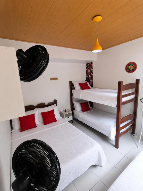 a room with two beds and a ceiling at Mandalas Guest House in Cabo Frio