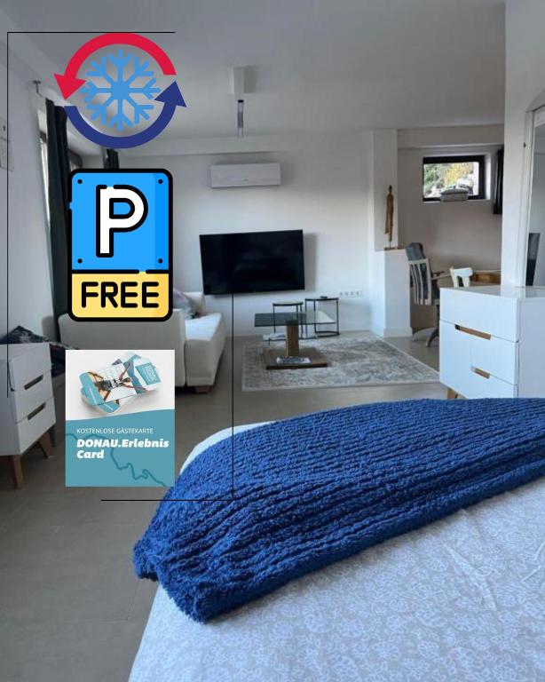 a bedroom with a blue bed and a living room at Studio Donau Radweg-Passau 4 km - Klimaanlage, Parkplatz kostenlos, DONAUErlebnis Card in Hinding