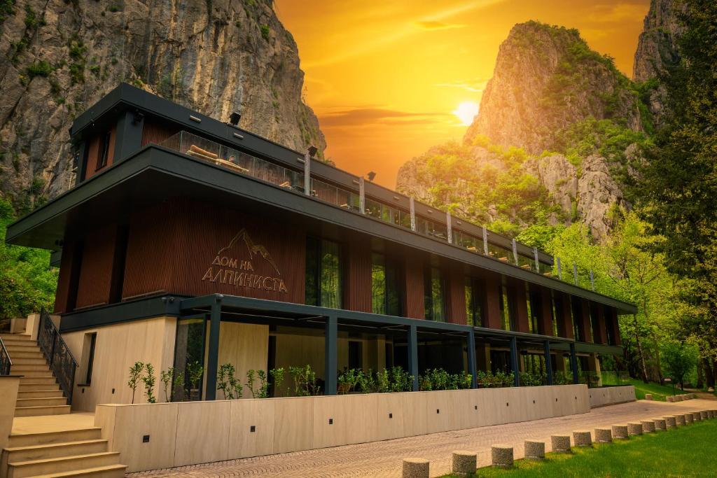 a building with a sunset in the background at Хотел Дом на Алпиниста in Vratsa