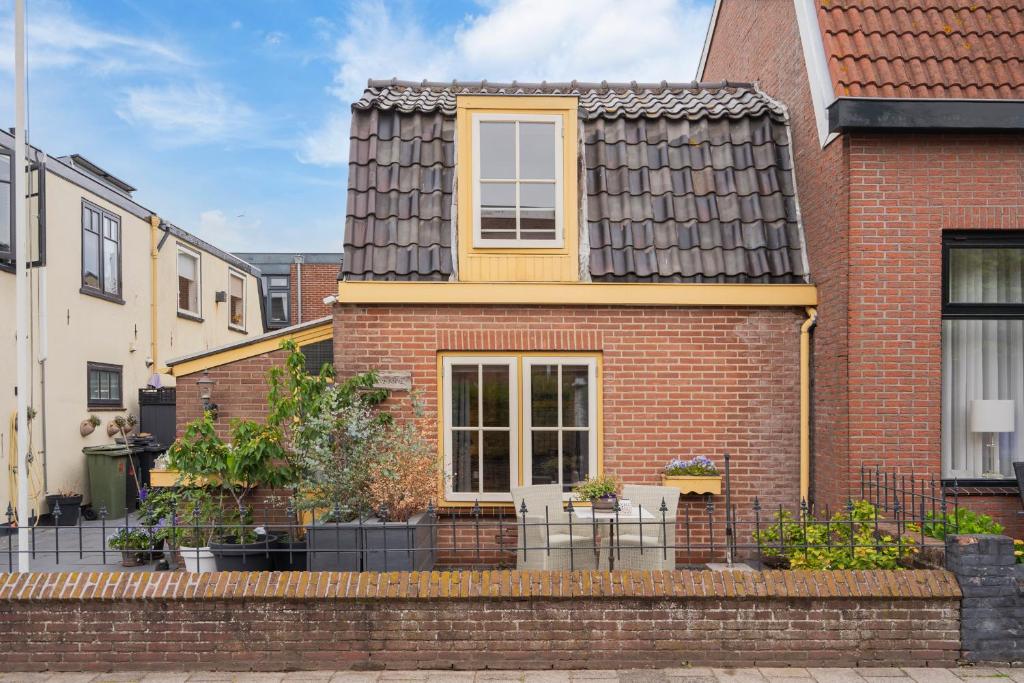a red brick house with a black roof at Huisje De Koning in Zandvoort