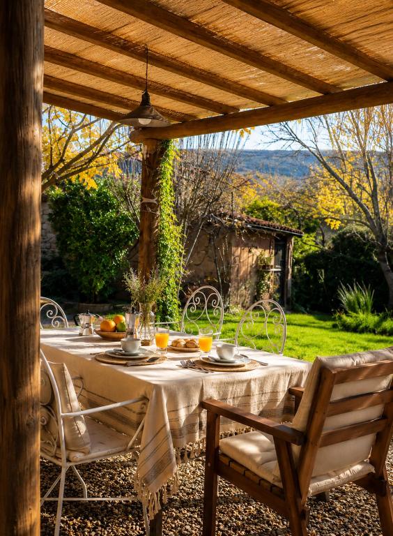a table and chairs sitting under a wooden pergola at LA CUMBRE-Calma, Desconexión y Piscinas Naturales en Sierra de Gata TR-CC-00490 in Gata