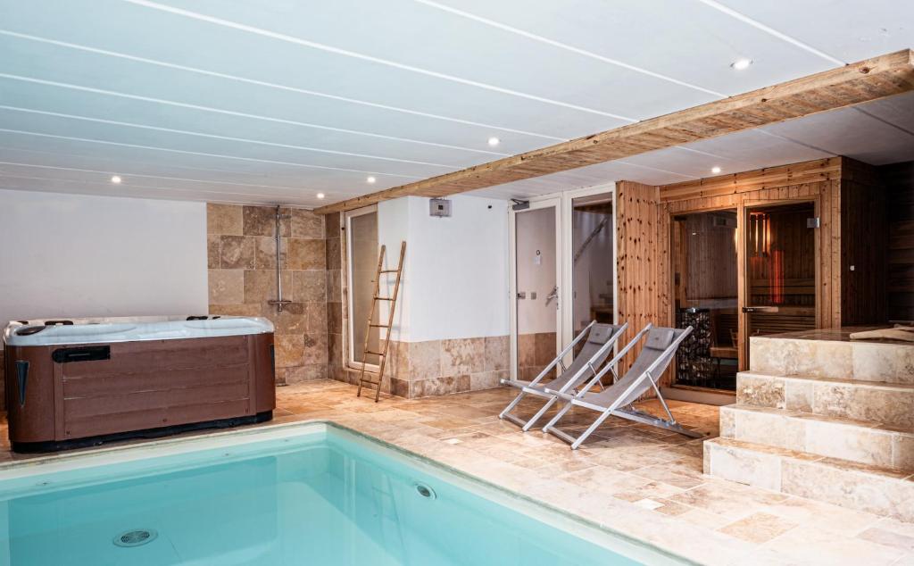 a room with a swimming pool with chairs and a kitchen at Les Gîtes de Sprimont - Le Cottage in Sprimont