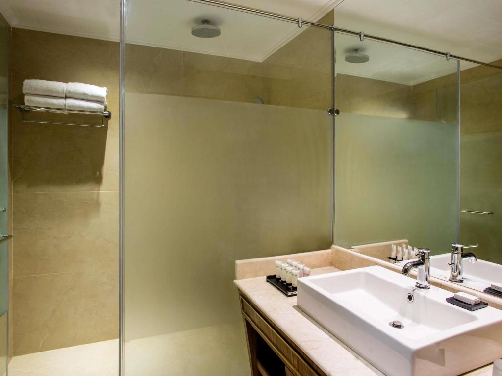 a bathroom with a sink and a shower at Mövenpick Hotel Cairo - Media City in 6th Of October