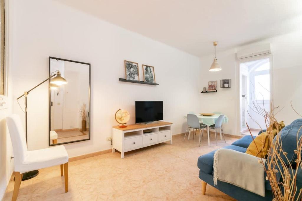 a living room with a blue couch and a mirror at Charming central gem in Poble Sec in Barcelona