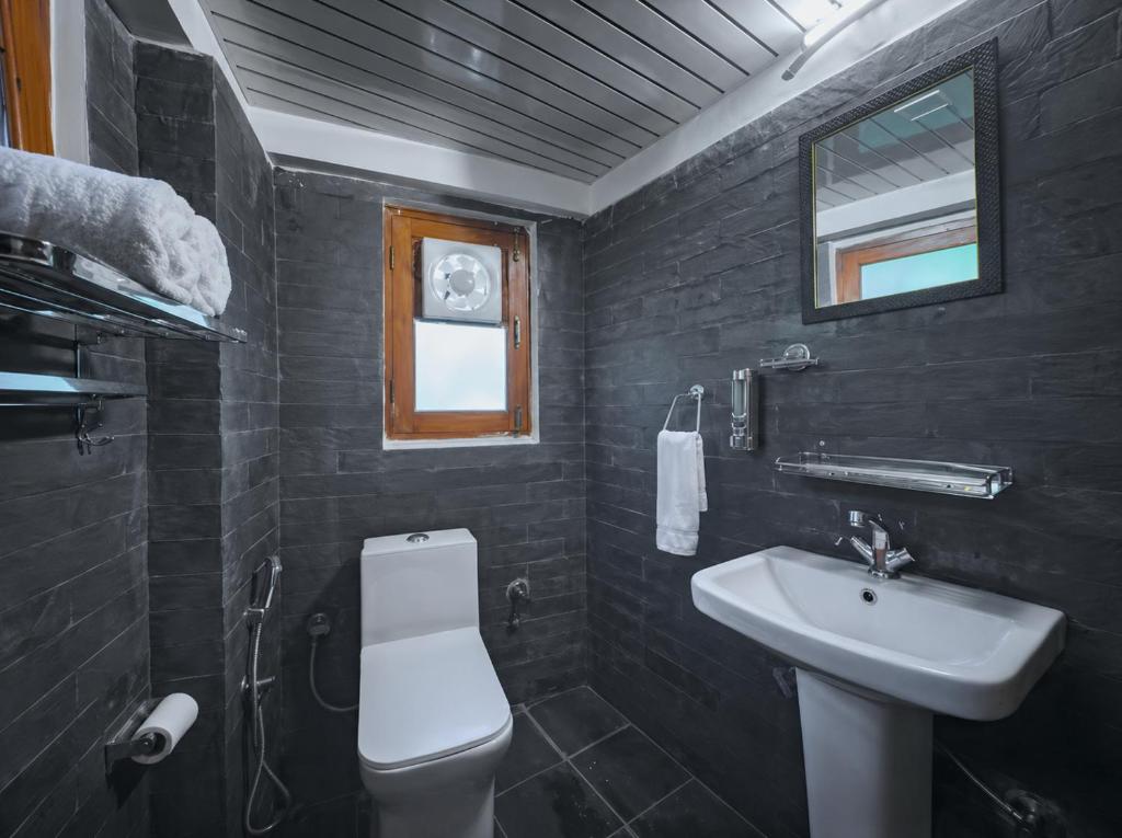 ein schwarzes Badezimmer mit Waschbecken und Toilette in der Unterkunft Annantam in Manali